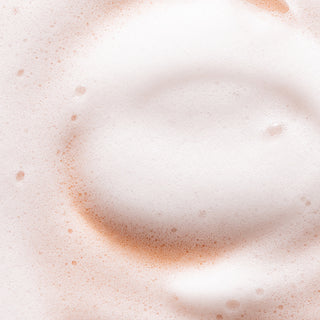 Close-up of white foam with a subtle pink tint and scattered bubbles, highlighting the creamy texture of our Blooming Jasmine Hydrating Foaming Hand Wash with aloe vera.