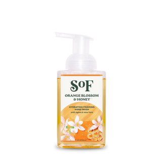 A clear pump bottle of Orange Blossom & Honey Hydrating Foaming Hand Wash contains orange liquid, floral and honeycomb label designs, features agave and aloe vera, and has a paraben free formula.