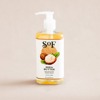 A clear, BPA-free pump bottle of Shea Butter Nourishing Hand Wash features an illustrated label with shea nuts and leaves, set against a neutral background.